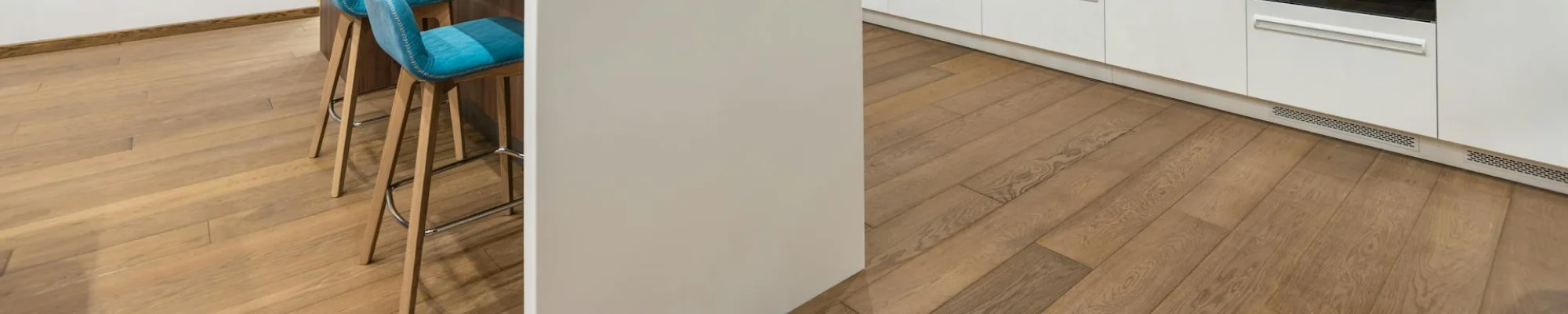 Kitchen with white waterfall countertop and brown hardwood floors