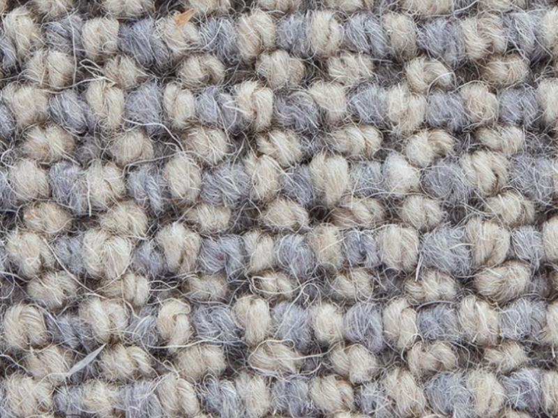 Closeup of grey and beige carpet fibers