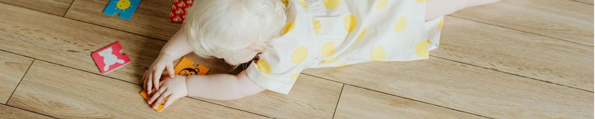 Baby playing with toys on light golden luxury vinyl flooring